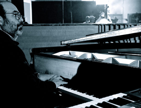 Thumbnail of http://A%20man%20with%20glasses%20plays%20the%20piano%20in%20a%20dimly%20lit%20room.%20His%20expression%20is%20focused,%20evoking%20a%20sense%20of%20concentration%20and%20passion%20for%20music.